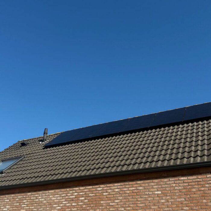 Zonnepanelen op een dak onder een blauwe lucht