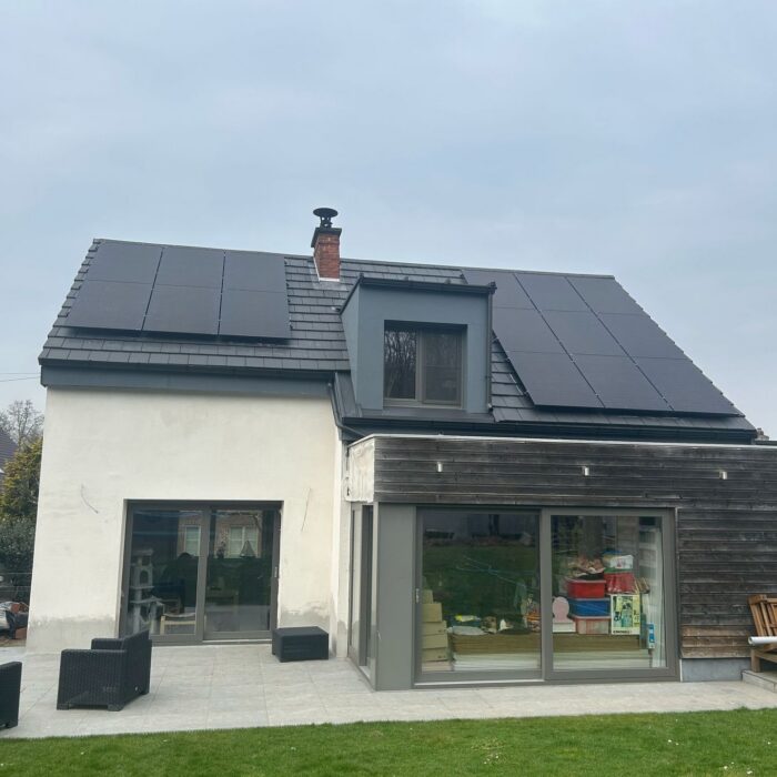 Zwarte zonnepanelen op het dak van een gerenoveerde woning